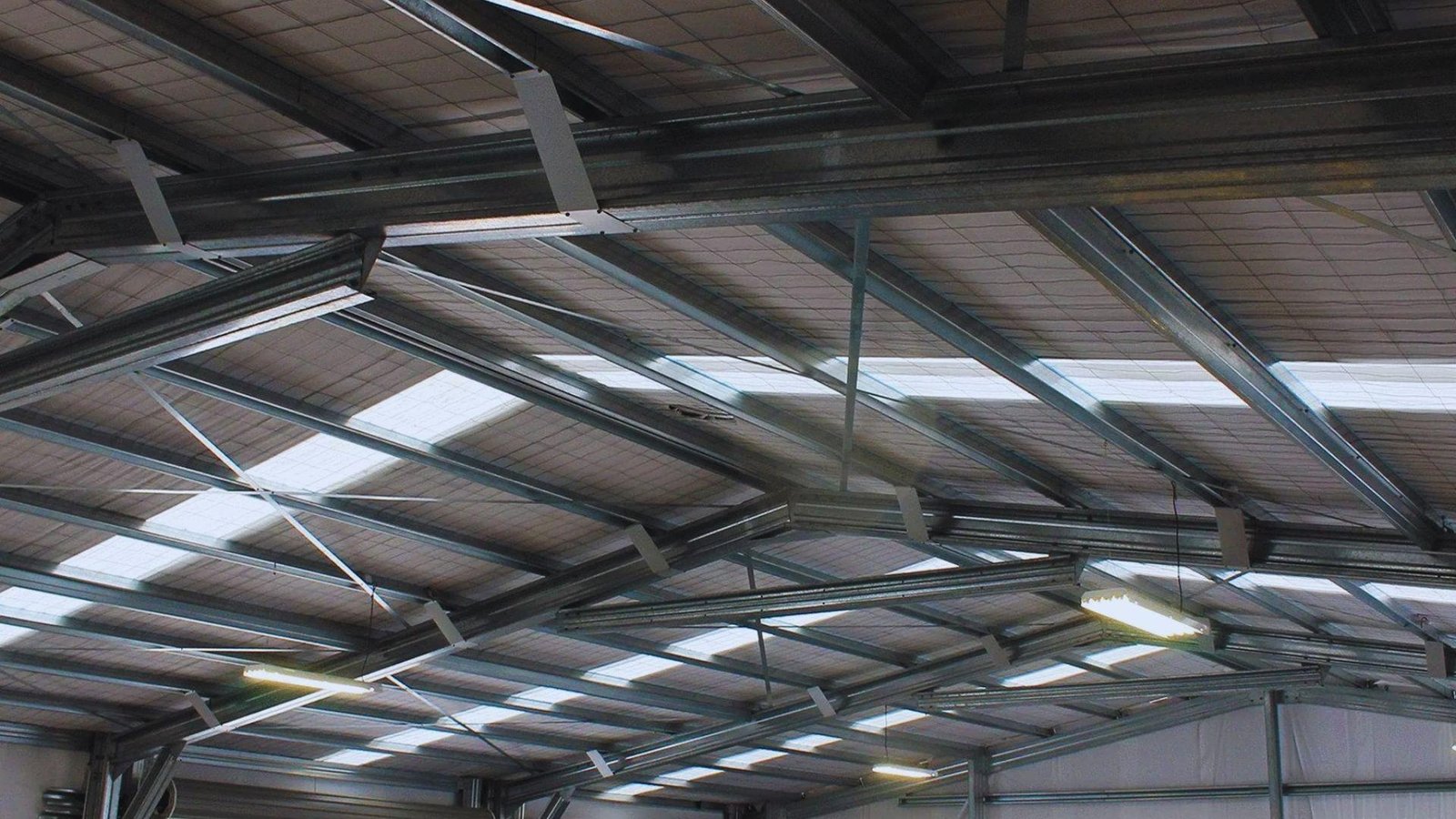 A large warehouse featuring a metal roof and multiple windows, showcasing its industrial architecture.