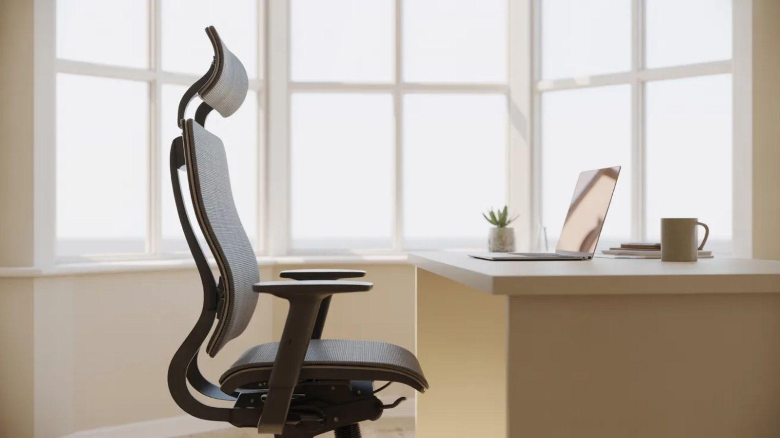 An ergonomic office chair next to a minimalist desk with a laptop, mug, and plant. Sunlight streams in through large windows, creating a calm, productive atmosphere.