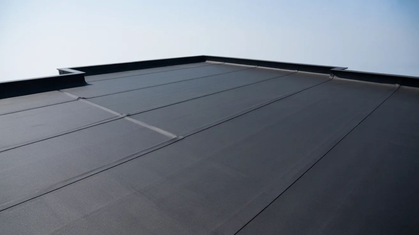A roof covered with a black roofing membrane, showcasing a smooth and uniform surface.