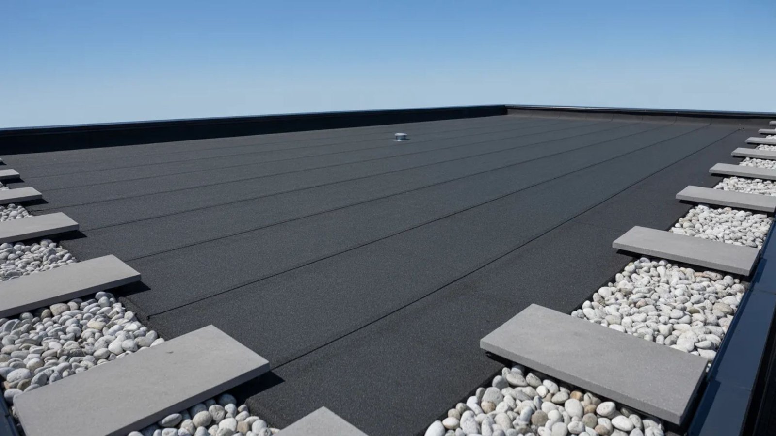A flat roof covered with a layer of gravel and small rocks, providing a textured surface.