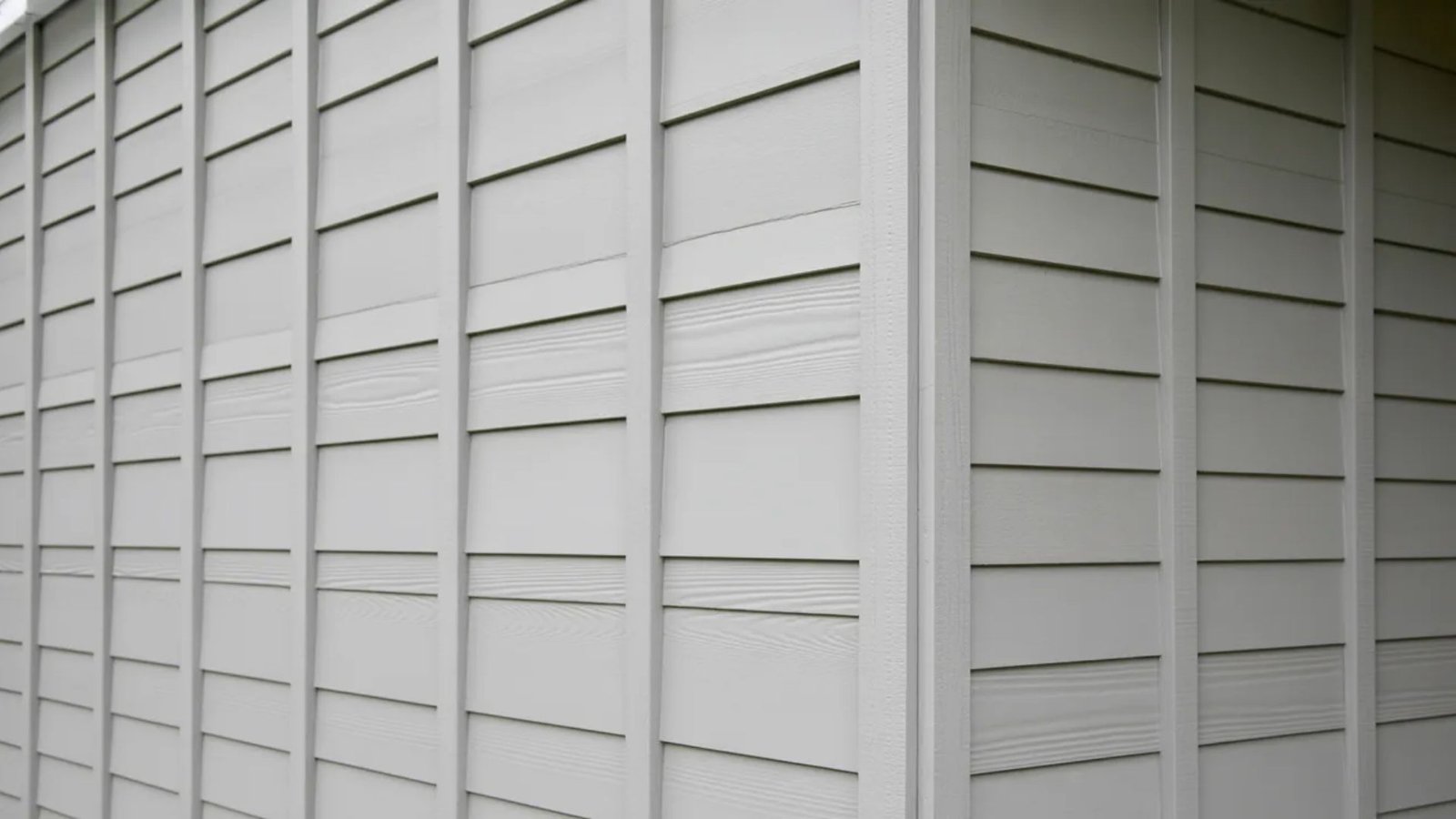 Close-up of a white house featuring textured siding and a well-maintained exterior.