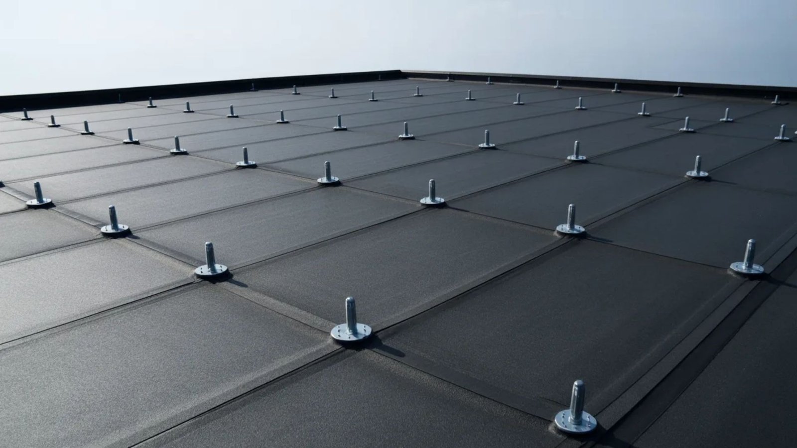 A close-up of a roof featuring metal studs and screws, highlighting the construction details.